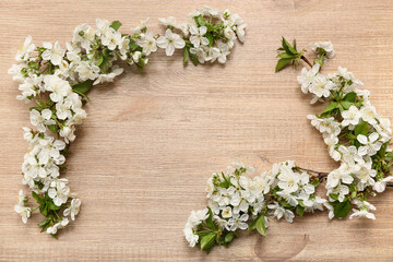 Frame made of beautiful blossoming branches on wooden background