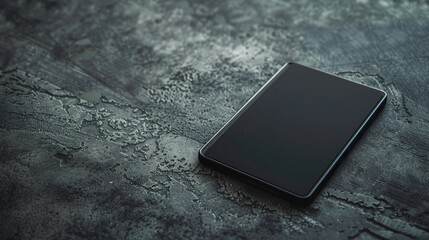 Dark tablet resting on a cement surface