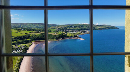 Looking through a window of the beautiful Glenariff Waterfoot Village on the Irish Sea Antrim Northern Ireland on a sunny day with a blue sky