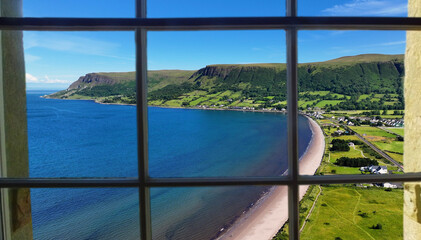 Looking through a window of the beautiful Glenariff Waterfoot Village on the Irish Sea Antrim Northern Ireland on a sunny day with a blue sky