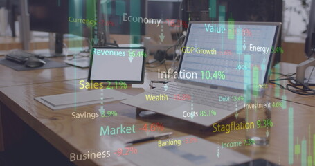 Image of financial data processing over laptop and tablet on desk at office