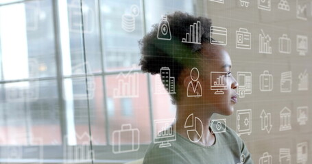 Image of business icons over smiling african american casual businesswoman at office