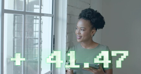 Image of financial data processing over african american businesswoman in office