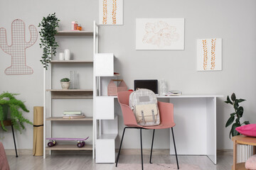 Interior of children's room with table and backpack on chair
