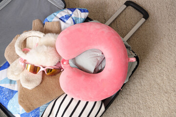 Suitcase with belongings on floor in room, closeup. Travel concept