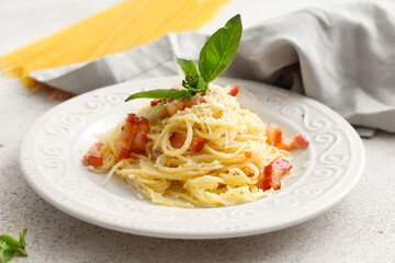 White plate with tasty pasta carbonara and napkin on table, closeup