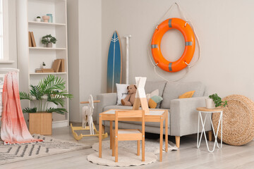 Kid's table with chair, rocking horse, soft sofa and lifebuoy ring in nursing room