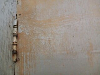 Rusty door hinges cut into the wooden door, connecting fasteners screwed in, construction parts.