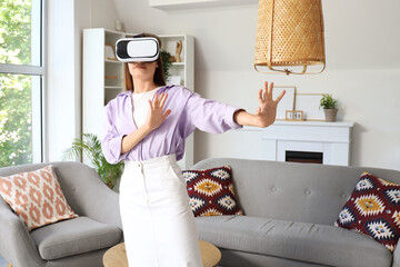 Young woman using VR glasses at home