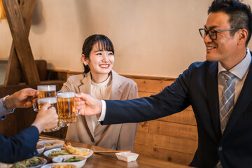居酒屋・飲み屋で乾杯する男女のサラリーマン
