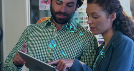 Image of ecology icons over diverse colleagues using tablet in office