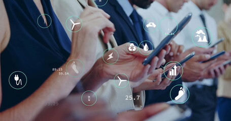 Image of ecology icons over diverse colleagues using smartphones in office