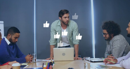 Image of media icons over diverse colleagues using laptop in office