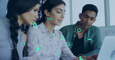 Image of ecology icons over diverse colleagues using laptop in office