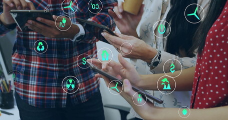 Image of ecology icons over diverse colleagues using tablet in office