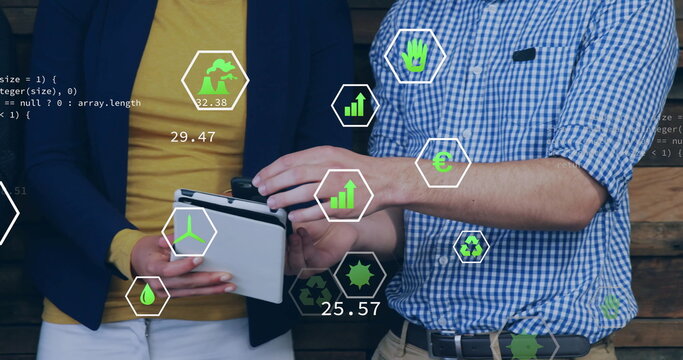 Image of ecology icons over diverse colleagues using tablet in office - Powered by Adobe