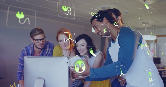 Image of ecology icons over diverse colleagues using tablet in office - Powered by Adobe