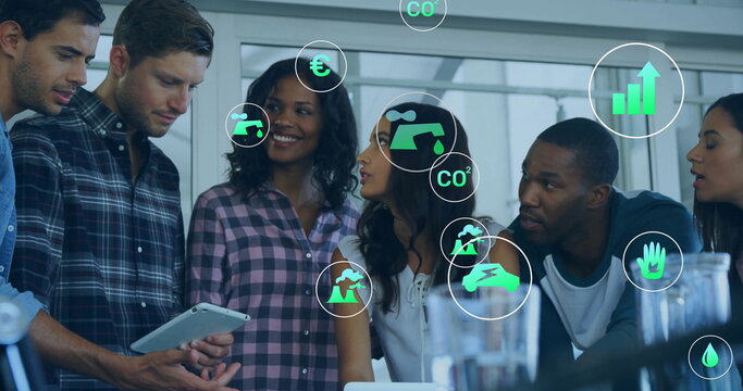 Image of ecology icons over diverse colleagues using tablet in office - Powered by Adobe