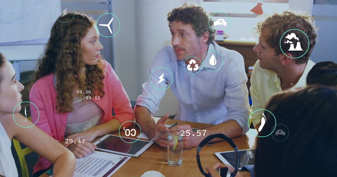 Image of ecology icons over diverse colleagues at meeting in office - Powered by Adobe