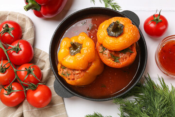 Tasty stuffed peppers and products on light table, flat lay