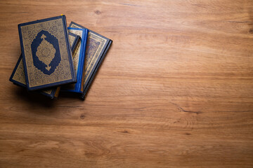 Ramadan, Eid mubarak, Islamic concept - The Holy Al Quran with written Arabic calligraphy meaning of Al Quran and rosary beads or tasbih, on wooden table, with copy space.