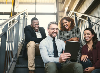 Tablet, team and funny business people in discussion for joke, story or comedy on steps. Technology, diversity or engagement manager with group laughing at meme in meeting for conversation in startup