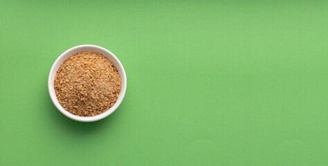 Powdered food based on soy fiber with psyllium fiber to cleanse the colon in the bowl - green color background