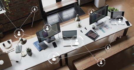 Image of digital icons with connections over computers on desks in office