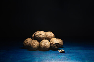 Comida. Nueces Chandler, amontonadas sobre mesa azul.