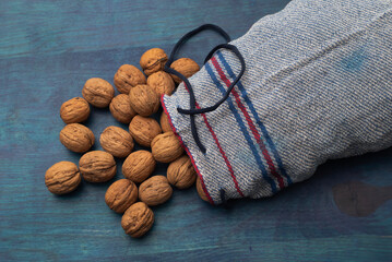 Comida. Bolsa azul con Nueces Chandler, sobre mesa azul. Plano cenital.