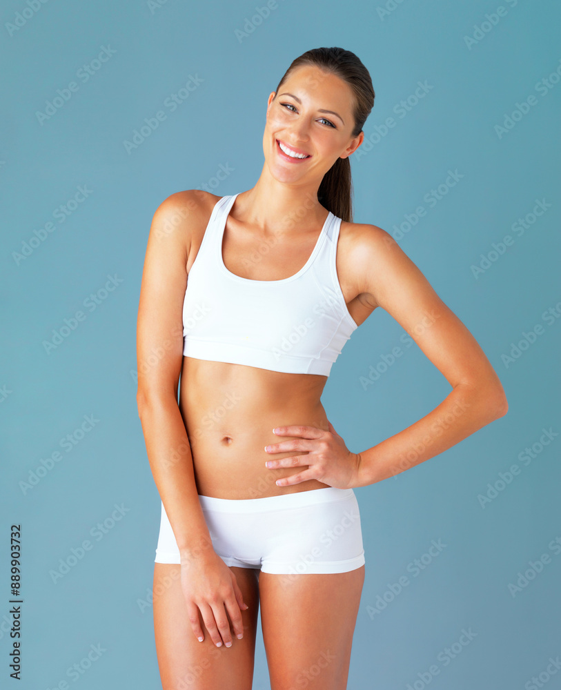 Sticker Woman, fitness and sports bra in studio portrait with smile for exercise, stomach and healthy body. Person, happy and pride for change, wellness and lose weight for transformation by blue background