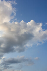 It's a blue sky with atmospheric puffy clouds.