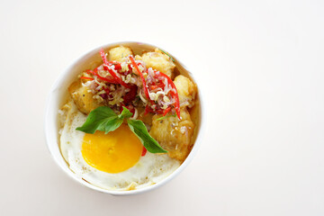 A bowl of food with meat and eggs