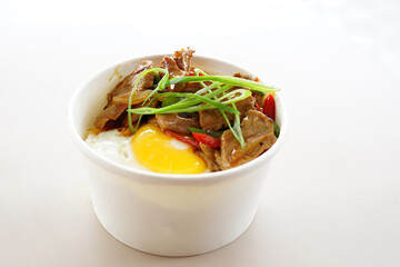 A bowl of food with meat and eggs