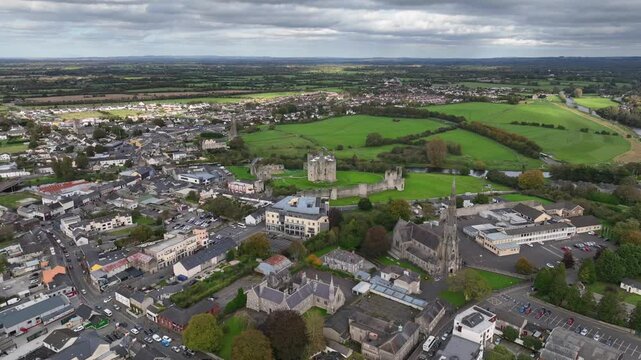 Trim Castle, County Meath, Ireland, October 2023. Drone clockwise orbit of the historic Norman Stronghold with St. Patrick's Chuch in the foreground surrounded by lush green fields on an overcast day.