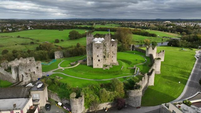 Trim Castle, County Meath, Ireland, October 2023. Drone clockwise orbit of a historic Norman Stronghold that sits on the edge of a town, surrounded by vibrant green grass on the River Boyne.