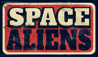 Fototapeta premium Aged and worn space aliens sign on wood