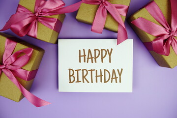 Happy Birthday card with gift box presents on purple background