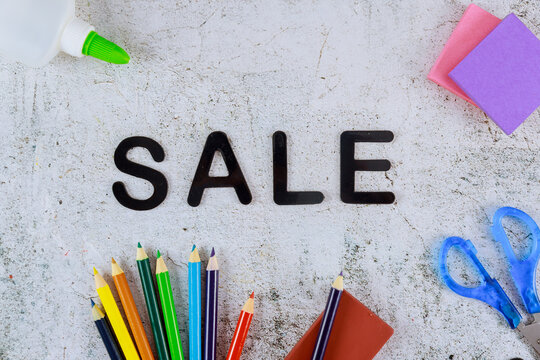 Word sale on light background with school supplies. Back to school.
