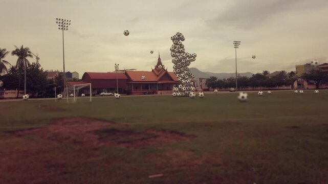 Giant CG Footballer made of Footballs playing Soccer on a real grass turf in Southeast Asia