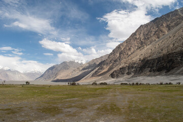the river with blue sky and sandstone mountains in nubra valley, leh ladakh, india