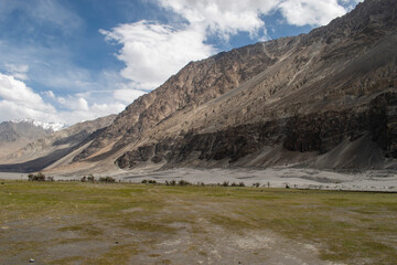 the river with blue sky and sandstone mountains in nubra valley, leh ladakh, india