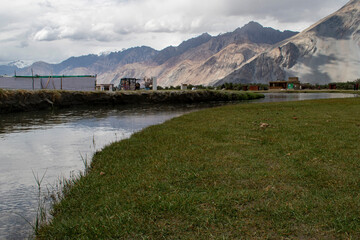 the river with blue sky and sandstone mountains in nubra valley, leh ladakh, india