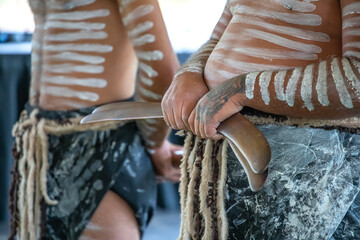 Australian aboriginal ceremony, human hand holds boomerangs for the welcome ritual rite at...