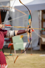 Medieval archery equipment, bow and arrow in the hands of a man