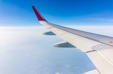 Obraz premium View from the airplane window at a beautiful cloudy sky and the airplane wing
