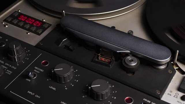 Professional Reel to Reel Audio Recorder and Player, Spinning Tape Over Magnetic Head and Time Counter, Close Up