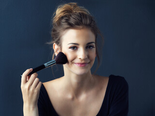 Obraz premium Happy woman, portrait and brush with makeup for beauty, blush or foundation on a blue studio background. Young female person or model with smile in facial treatment for cosmetics, glow up or shine