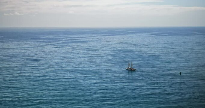 Small, beautiful tonga boat heading out to sea - high, wide, drone shot