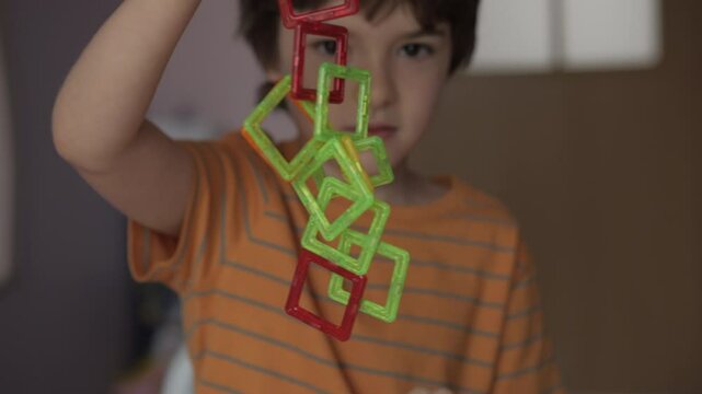 Magnetic Force Demonstration Showing Attraction. Boy Playing With Magnetic Tiles Stacking Blocks Game Set Toy. Development of Attention and Imagination. Creativity and Learning in Childhood.